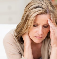 Woman holding her head and looking down.
