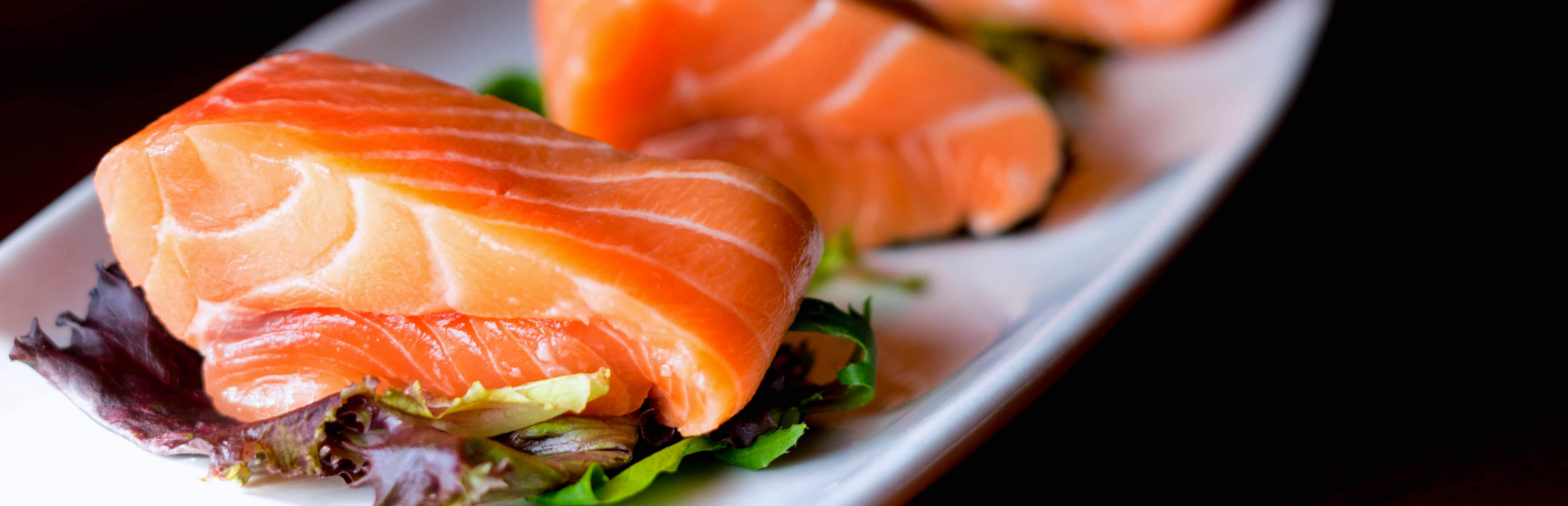 Three pieces of Salmon over mixed greens
